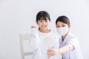 歯医者さんでブラッシング指導を受ける女の子の写真