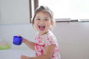 コップをもって口をゆすぐ(うがいする)女の子の写真